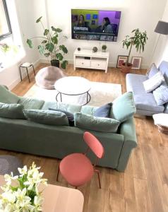 a living room with a green couch and a table at Large 2bed flat near TowerBridge in London