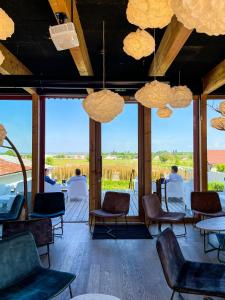 a room with chairs and tables and large windows at La Cuverie de Vosne in Vosne-Romanée