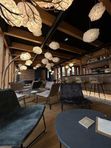 une salle avec des chaises, des tables et un bar dans l'établissement La Cuverie de Vosne, à Vosne-Romanée