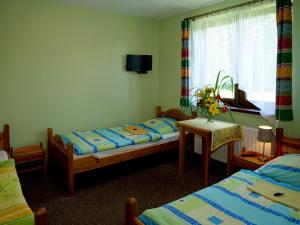 um quarto com 2 camas, uma mesa e uma janela em Mikołajówka em Stronie Śląskie