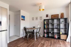 een eetkamer met een tafel en een boekenplank bij Charming 2 Bed Home in Edwalton in Nottingham