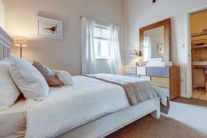 a white bedroom with a bed and a mirror at Sansoms Loft in Woodstock