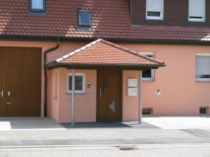 uma casa com uma porta castanha e um telhado vermelho em Gästeapartments Haus Kohler em Abstatt