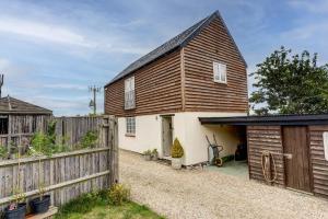 a barn conversion with a wooden fence and a garage at Sansoms Loft in Woodstock