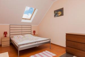 a small bedroom with a bed and a skylight at Holiday House Neptun by Renters in Kołczewo