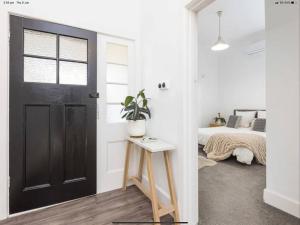 a bedroom with a black door and a bed at Walnut Cottage in Mildura