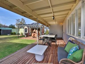 a patio with a table and chairs and a grill at Walnut Cottage in Mildura