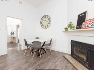 a dining room with a table and chairs and a fireplace at Walnut Cottage in Mildura
