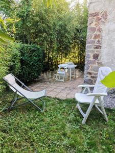 twee stoelen en een tafel in de tuin bij Chambre double avec salle de bains privative in Moyon