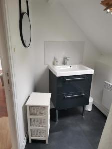 a bathroom with a black sink and a white counter at Chambre double avec salle de bains privative in Moyon