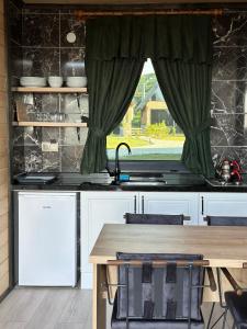 a kitchen with a table and a sink and a window at Of Çamlık bungalov in Of