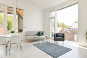 a living room with a table and chairs and windows at Kotimaailma - Kaunis saunallinen kattohuoneisto 10lle, Espoon keskustassa in Espoo