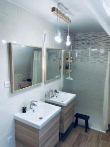 a bathroom with two sinks and a mirror and a shower at Maison de campagne à 2h de Paris in Droué