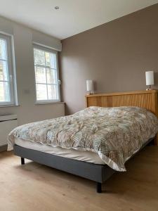 una camera con un letto in una stanza con due finestre di Gîte de l’abbaye a Fécamp