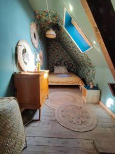 a room with a bed and a dresser in a attic at Maison de campagne à 2h de Paris in Droué