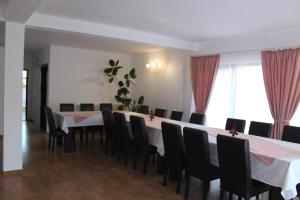 a dining room with a long table and chairs at Popas de munte Dâmbovicioara in Podu Dîmboviţei