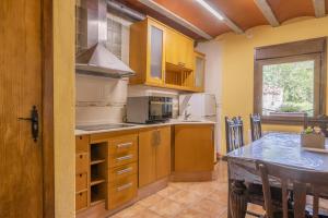 uma cozinha com armários de madeira e uma mesa de jantar em Mossen Batista Faig em Les Iglésies