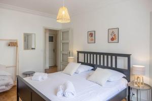 um quarto com uma grande cama branca com toalhas em Le Chancelier *T2* em Orléans