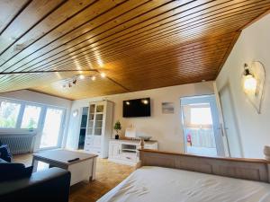 um quarto com uma cama e um tecto de madeira em Friedrichshafen im Grünen genießen em Friedrichshafen