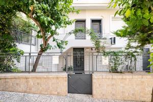 a gate in front of a white building at Renovated 1st-floor apt-close to the park in Athens