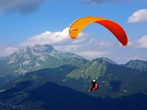 een persoon op een parachute in de lucht bij Chalet La Grangerie in Montriond