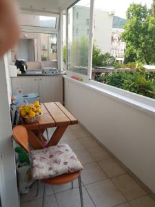 einen kleinen Balkon mit einem Tisch und einer Obstschale in der Unterkunft Apartman Batuta in Budva