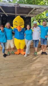 een groep mensen die poseren met een grote gele eenden mascotte bij Camping Paradis Bellerive in Montfrin