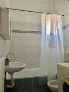 uma casa de banho com um lavatório, uma banheira e um WC. em Traveller's home em Litochoro