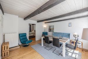 una sala da pranzo con tavolo e sedie blu di fewo1846 - Dampfer Alexandra - urige Wohnung mit zwei Schlafzimmern am Nordermarkt im Stadtzentrum a Flensburgo