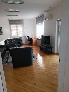 ein Wohnzimmer mit einem Sofa und einem TV in der Unterkunft Apartman Nodi in Sarajevo