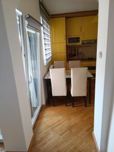 eine Küche mit einem Tisch und 2 weißen Stühlen in der Unterkunft Apartman Nodi in Sarajevo