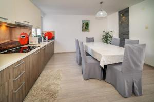 una cucina e una sala da pranzo con tavolo e sedie di Apartments Kricin 14 Laura a Baška