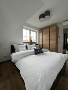 un grande letto bianco in una camera da letto con finestra di Winkelschiffchen III mit Sauna a Juist