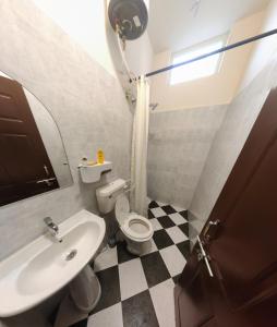 a bathroom with a toilet and a sink at The Sunshine Bungalow in Bangalore
