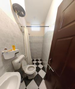 a small bathroom with a toilet and a sink at The Sunshine Bungalow in Bangalore