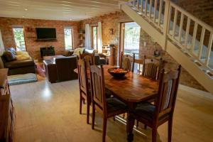 a living room with a wooden table and a staircase at Valley Farm Stay in Knysna