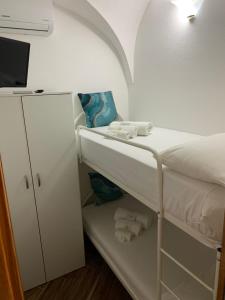 Cette petite chambre comprend des lits superposés et un réfrigérateur. dans l'établissement Casa Balilla, à La Maddalena