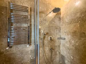 La salle de bains est pourvue d'une douche avec une porte en verre. dans l'établissement Konak Ballıca - Deluxe Suite, à Avanos