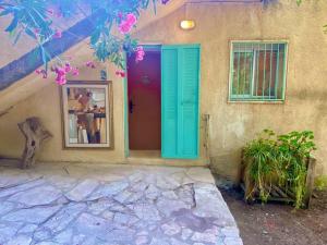 a house with a blue door and a window at La Rustique Studio with a Spectacular View in Bet Zayit