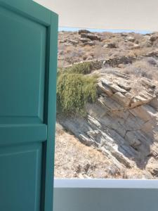 a green door with a view of a mountain at Aetherian Suites in Loutra