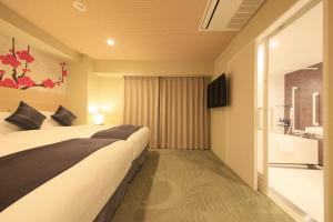 大阪市にあるMeander Osakaのベッドとバスタブ付きのホテルルームです。