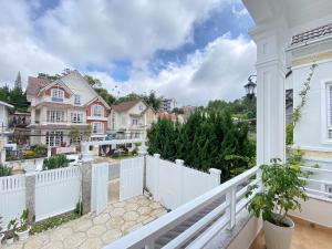 a balcony with a white fence and houses at Villa Minh Tuyet Dalat in Da Lat