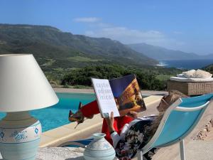 a table with a lamp and a chair next to a pool at Villa Dama luxury in Alghero