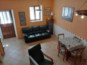 ein Wohnzimmer mit einem schwarzen Ledersofa und einem Tisch in der Unterkunft Le meridiane in Piè la Costa