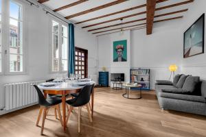 - un salon avec une table, des chaises et un canapé dans l'établissement Lucena - Charmant appt en centre-ville, à Toulouse
