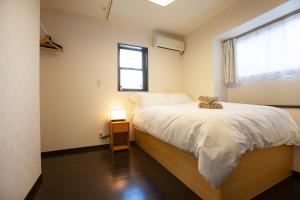 Un dormitorio con una cama con un osito de peluche. en KS west Waseda 1F, en Tokio