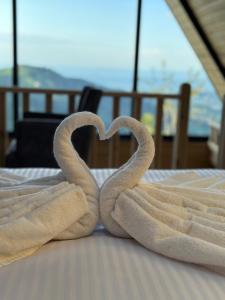 - 2 serviettes en forme de cœur sur un lit dans l'établissement Of Çamlık bungalov, à Of