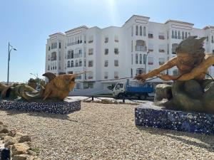 twee bronzen beelden van vogels voor een gebouw bij Apartamentos Costa Luz in Matalascañas