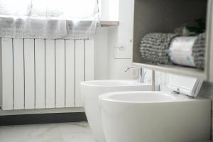 a white bathroom with a toilet and a sink at La Casa di Sossy in Civitanova Marche