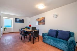 - un salon avec un canapé et une table avec des chaises dans l'établissement Panoramic Bastioni Sea View, à Alghero